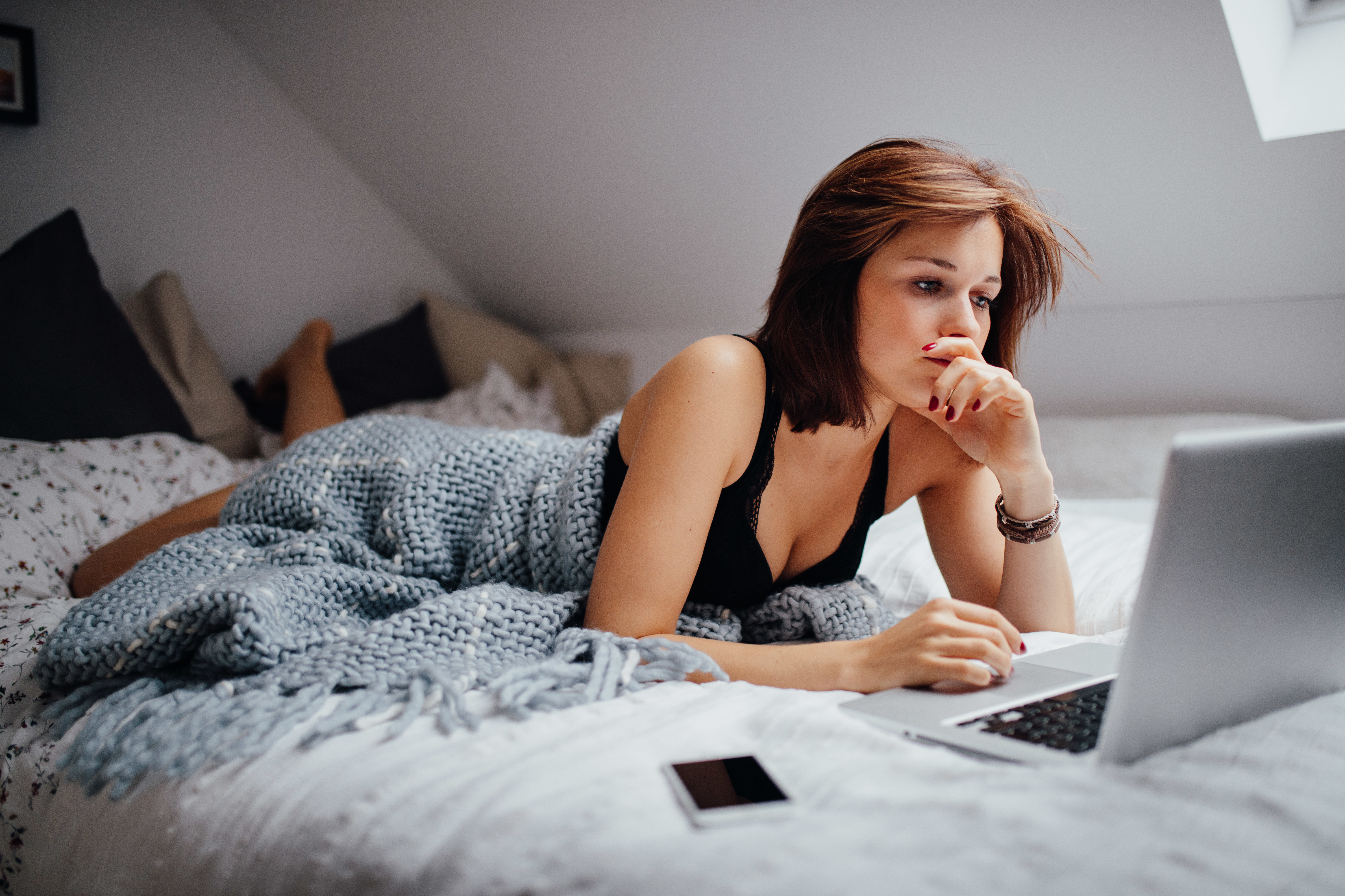 Develop-University-young-woman-studying-with-laptop-on-bed